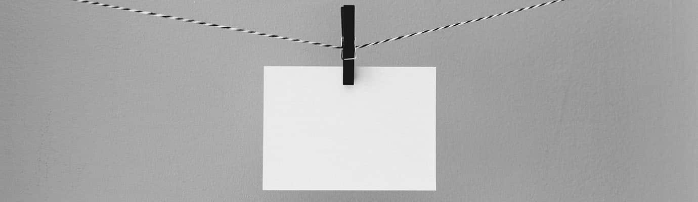 a white sheet of paper hangs on the line with a clip