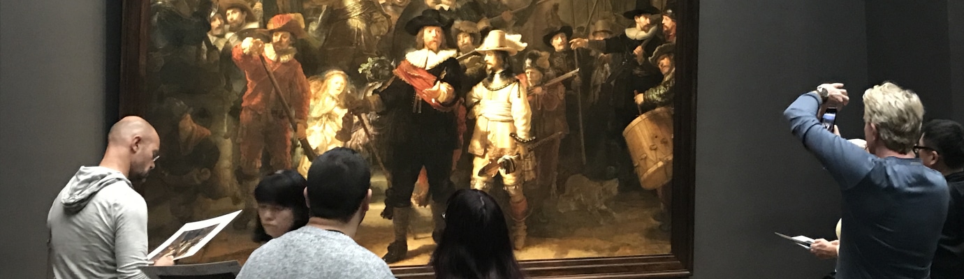 People in front of a painting in the Amsterdam Rijksmuseum