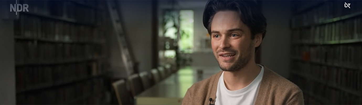 Screenshot from ZAPP report: Tobias Mast in an interview in front of a dark background