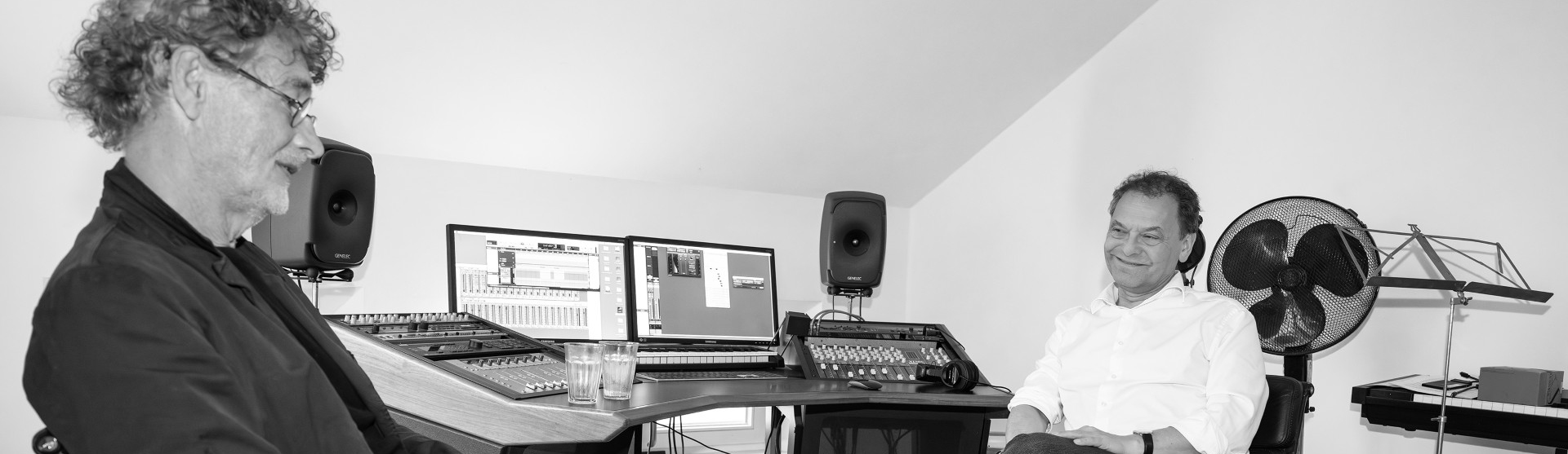 two people in front of a sound mixing console