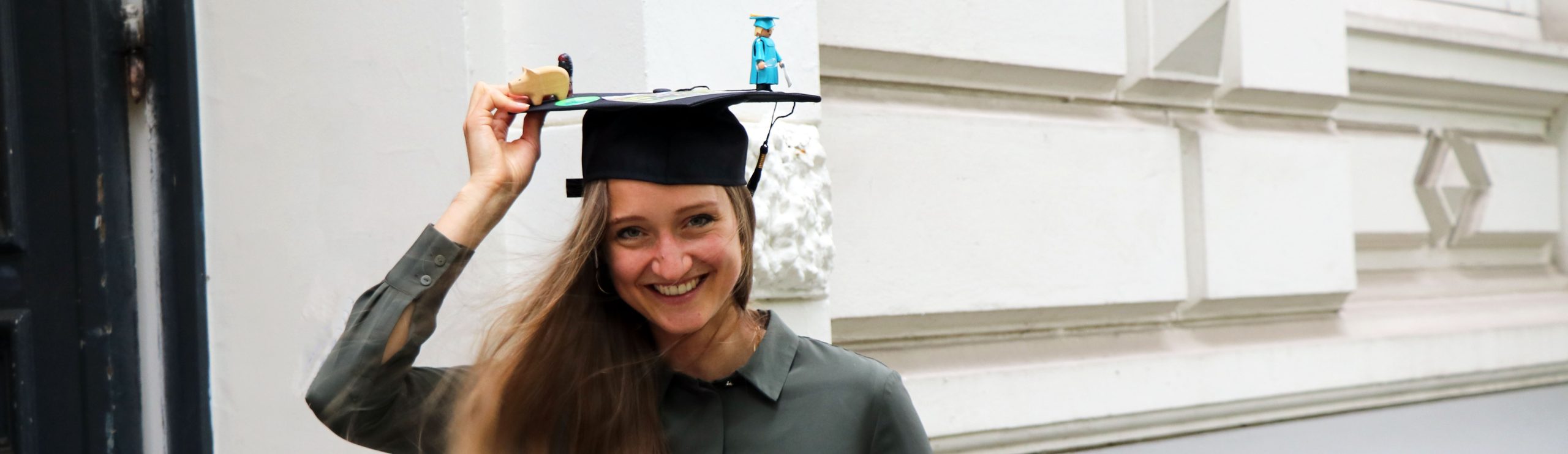 Leonie Wunderlich holds on tightly to her doctoral cap, which is threatening to fly away.