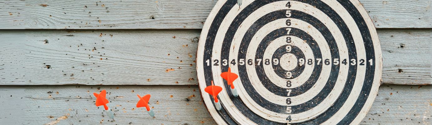 Dartboard with red arrows on a wall.