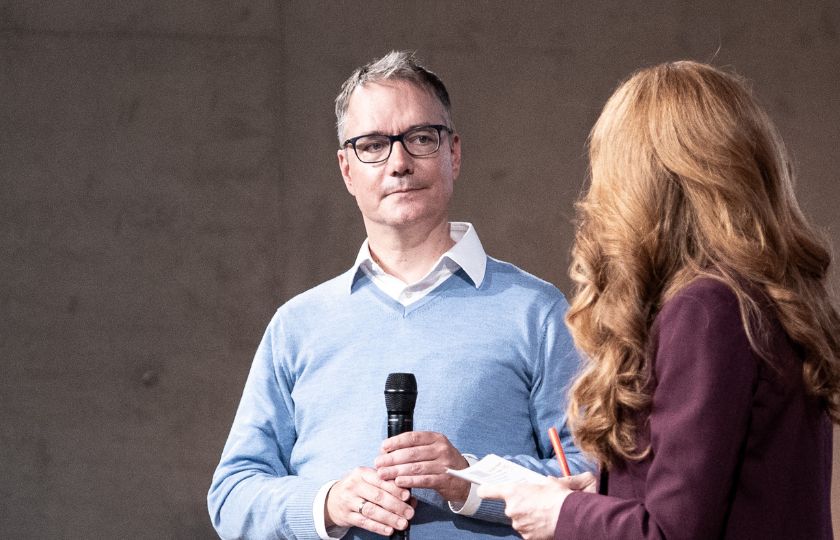 Jan-Hinrik Schmidt mit einem Mikrofon in der Hand.