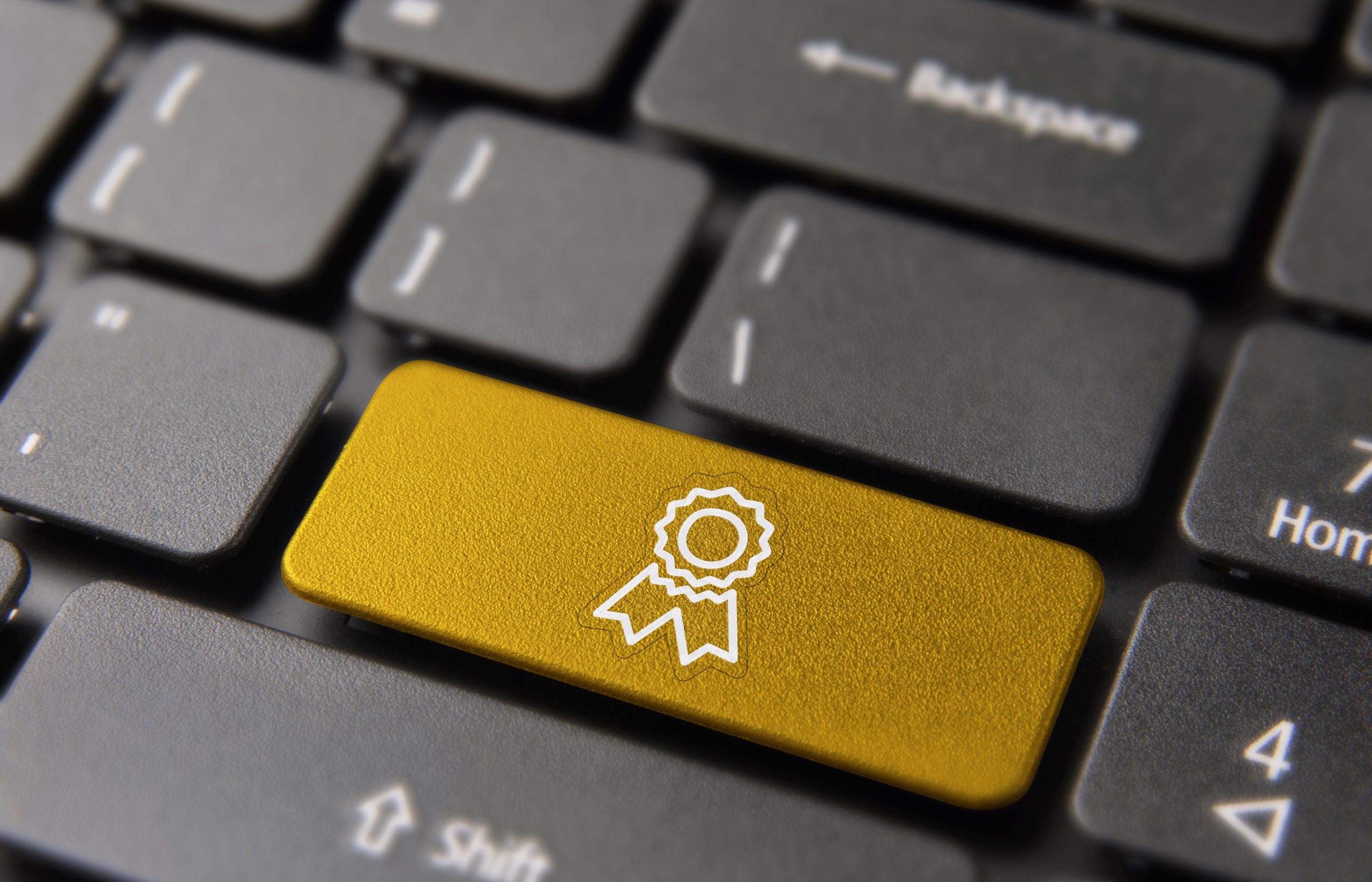 Tastatur mit einer goldfarbenen Taste, die ein weißes Abzeichen zeigt