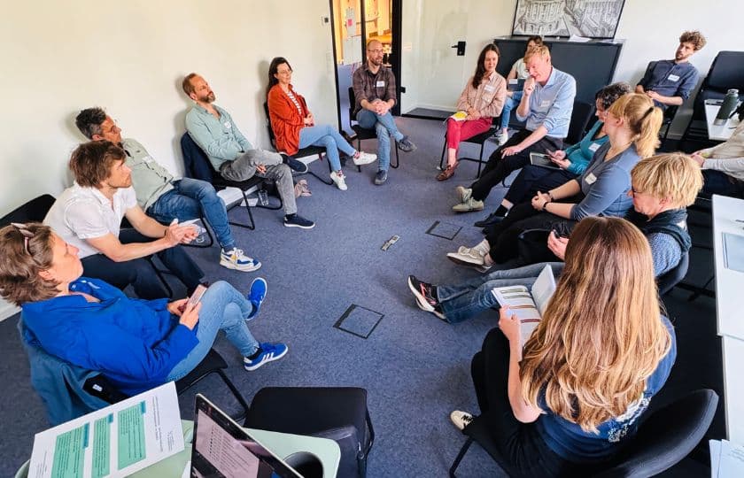 Bild aus der Research Clinic: eine Gruppe Menschen sitzt im Kreis und diskutiert