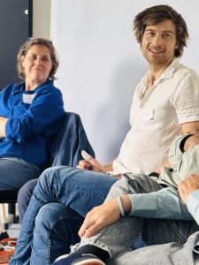 zwei fröhliche Personen (Anja und Simon) beteiligen sich an der Diskussion