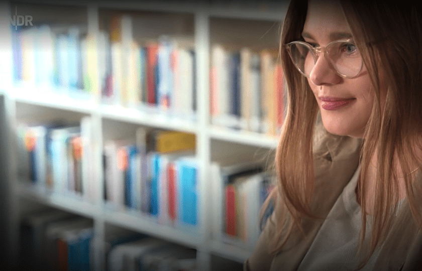 Portrait Julia Behre vor Bücherwand