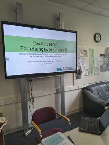 Whiteboard mit der Start-Folie, Aufschrift "Partizipative Forschungsworkshops II"