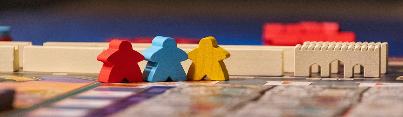 Drei Holzfiguren in rot, blau und gelb