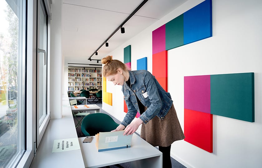 junge Frau beugt sich über ein Buch in der Bibliothek des HBI